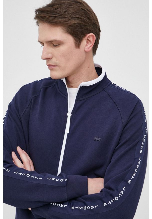 Lacoste Bluza męska kolor granatowy gładka. Okazja: na co dzień. Kolor: niebieski. Materiał: dzianina. Długość rękawa: raglanowy rękaw. Wzór: gładki. Styl: casual