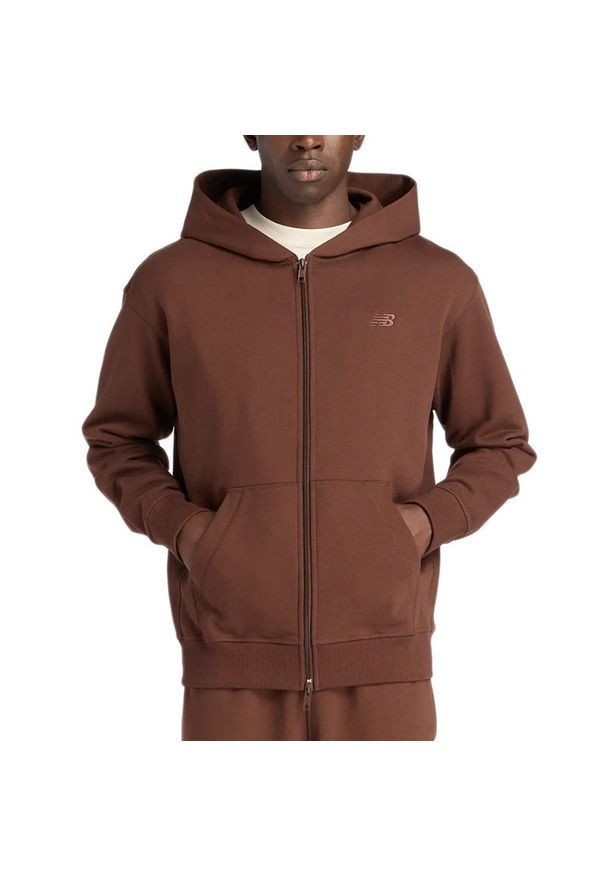 Bluza męska New Balance MJ53506ABJ - brązowa. Typ kołnierza: kaptur. Kolor: brązowy. Materiał: dresówka, bawełna. Wzór: napisy. Styl: klasyczny