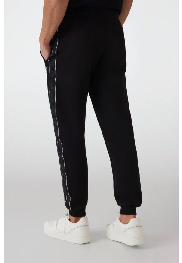 Guess - GUESS Czarne męskie spodnie dresowe z lampasami Mickey, Rozmiar L. Kolor: czarny. Materiał: dresówka