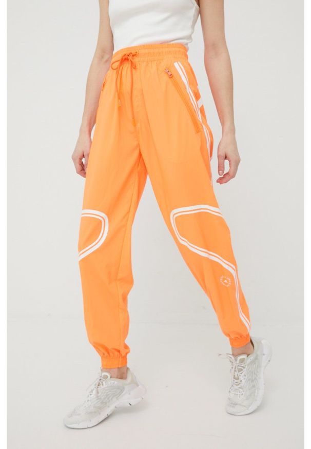 Adidas by Stella McCartney - adidas by Stella McCartney spodnie treningowe Truepace HC2985 damskie kolor pomarańczowy z nadrukiem. Kolor: pomarańczowy. Materiał: materiał. Wzór: nadruk