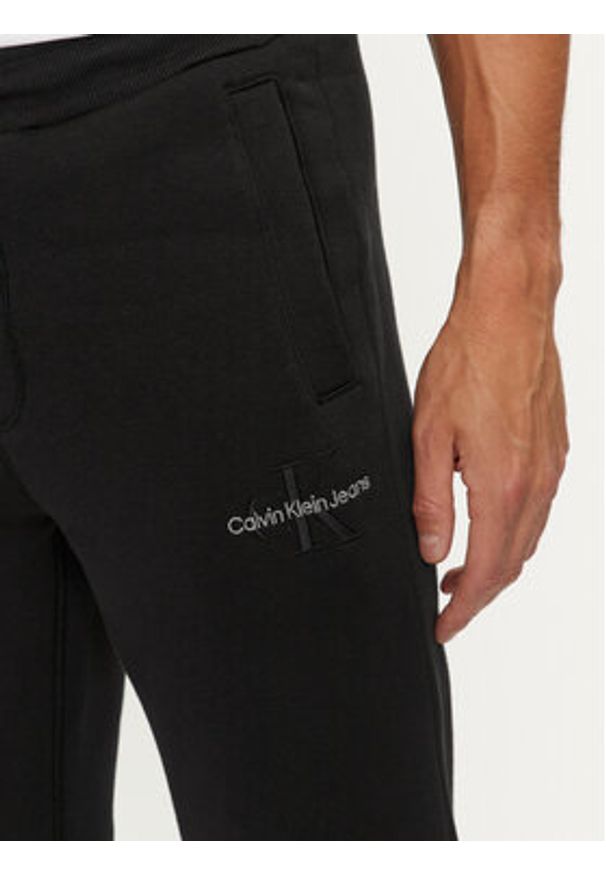 Calvin Klein Jeans Spodnie dresowe Monologo J30J325658 Czarny Regular Fit. Kolor: czarny. Materiał: syntetyk