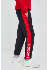 Lacoste spodnie dresowe kolor czerwony wzorzyste. Kolor: czerwony. Materiał: dresówka #1