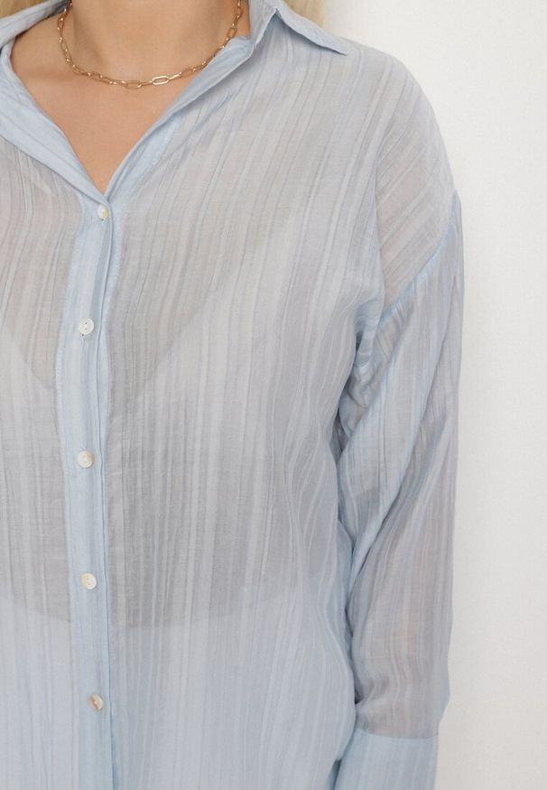 Born2be - Jasnoniebieska Koszula o Kroju Oversize Dolamana. Okazja: na co dzień. Typ kołnierza: kołnierzyk klasyczny. Kolor: niebieski. Materiał: jeans. Długość rękawa: długi rękaw. Długość: długie. Styl: klasyczny, elegancki, casual