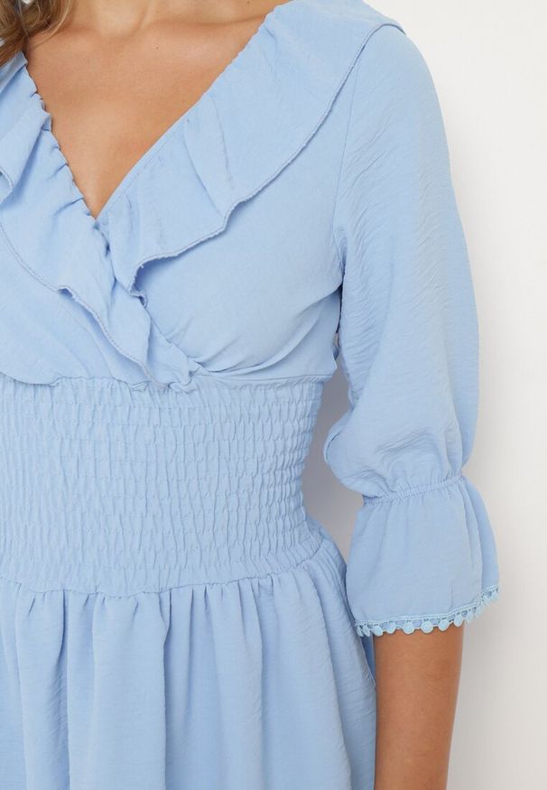 Born2be - Jasnoniebieska Sukienka z Kopertowym Dekoltem i Gumką w Pasie Ozdobiona Falbanką Tesalie. Okazja: na co dzień. Typ kołnierza: kołnierz z falbankami, dekolt kopertowy. Kolor: niebieski. Wzór: aplikacja. Sezon: wiosna, lato. Typ sukienki: kopertowe. Styl: casual, elegancki