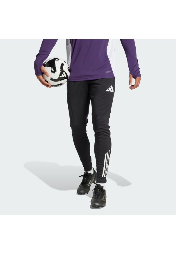 Adidas - Spodnie Manchester United Tiro 25 Competition Training. Kolor: czarny, fioletowy, wielokolorowy. Sport: piłka nożna