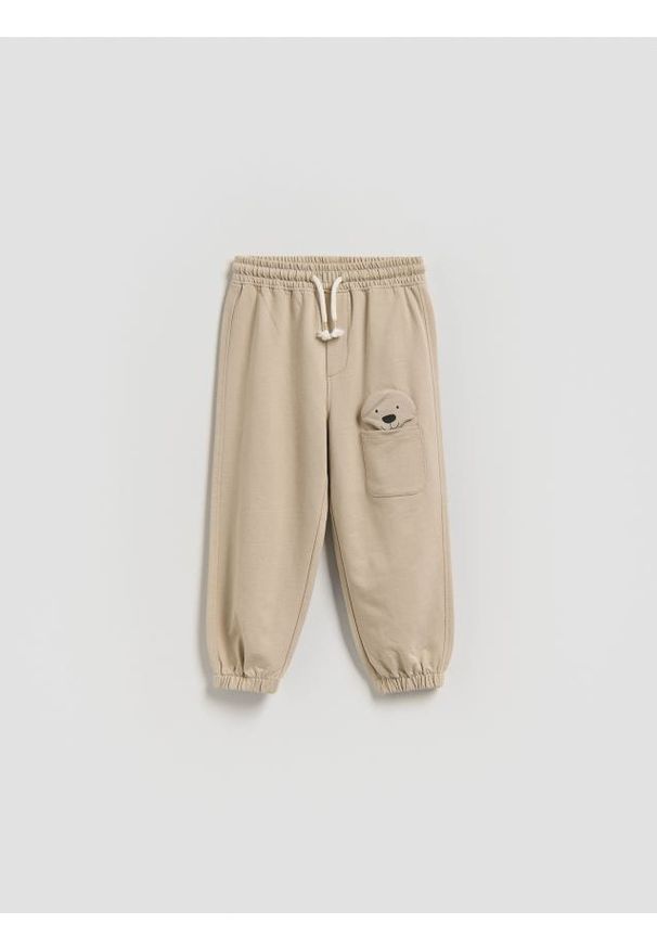 Reserved - Spodnie z aplikacją - beżowy. Kolor: beżowy. Materiał: dzianina, bawełna. Wzór: aplikacja