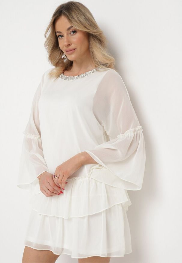 Born2be - Jasnobeżowa Rozkloszowana Sukienka Mini z Dekoltem Ozdobionym Cyrkoniami i Falbanką Stevianta. Kolor: beżowy. Wzór: aplikacja. Długość: mini