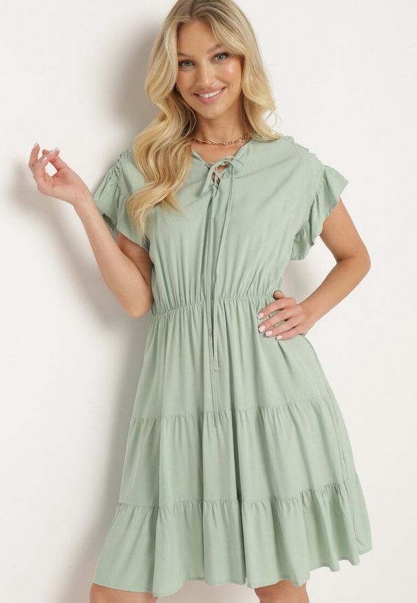 Born2be - Miętowa Sukienka z Gumką w Pasie Ozdobiona Falbanką i Wiązana Materiałowym Paskiem Tiamalou. Typ kołnierza: dekolt w łódkę. Kolor: miętowy. Materiał: materiał. Długość rękawa: krótki rękaw. Wzór: aplikacja