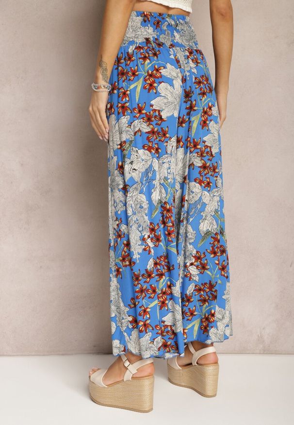 Renee - Niebieskie Spodnie z Wiskozy z Gumką w Talii i Szerokimi Nogawkami w Kwiaty Selinia. Kolor: niebieski. Materiał: wiskoza. Wzór: kwiaty