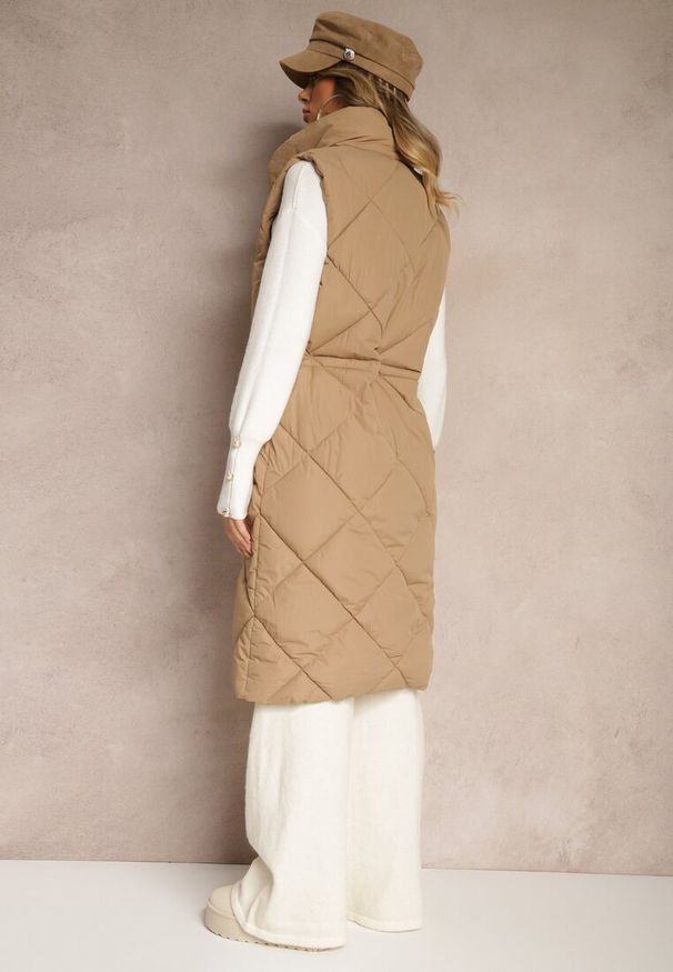 Renee - Ciemnobeżowa Długa Kamizelka z Pikowanymi Przeszyciami ze Stójką i Kieszeniami Avalithe. Okazja: na spacer, na co dzień. Typ kołnierza: kołnierzyk stójkowy. Kolor: beżowy. Materiał: jeans. Długość: długie. Styl: casual, elegancki, sportowy