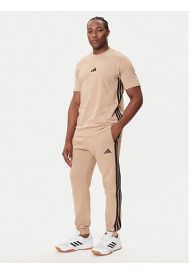 Adidas - adidas Spodnie dresowe Essentials 3-Stripes JX0712 Beżowy Regular Fit. Kolor: beżowy. Materiał: syntetyk, bawełna