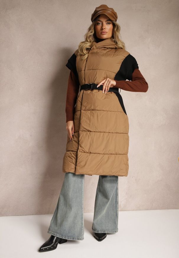 Renee - Jasnobrązowa Długa Kamizelka z Pikowanego Materiału o Kopertowym Kroju z Kapturem i Paskiem Nerietta. Okazja: na spacer, na co dzień. Typ kołnierza: kaptur. Kolor: brązowy. Materiał: materiał. Długość: długie. Styl: klasyczny, casual, elegancki