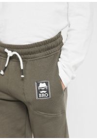 Spodnie sportowe chłopięce "BRO" (2 pary), bawełna organiczna bonprix ciemnoniebiesko-ciemnooliwkowy. Kolor: niebieski. Materiał: bawełna. Wzór: aplikacja. Styl: sportowy #3