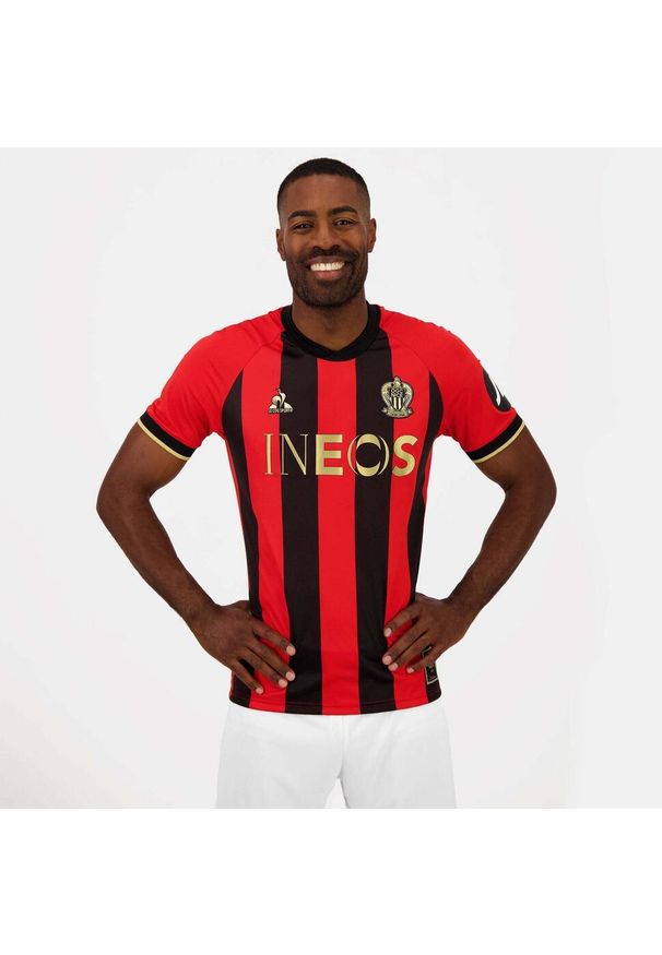 Le Coq Sportif - Koszulka domowa OGC Nice 2024/2025. Kolor: czerwony, wielokolorowy, czarny. Sport: piłka nożna
