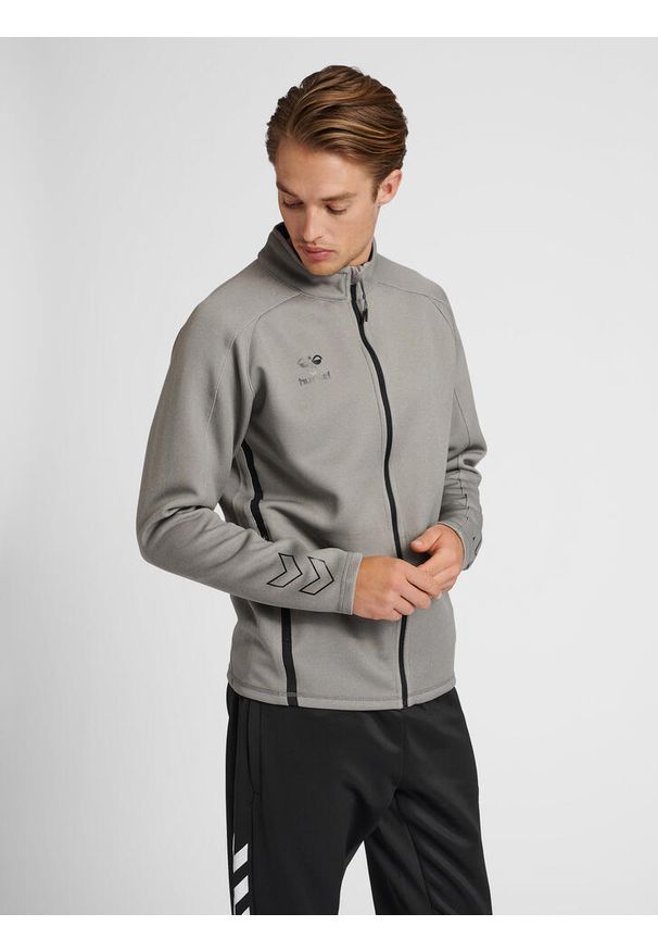 Bluza dresowa zapinana na zamek błyskawiczny Hummel Cima XK. Kolor: szary. Materiał: dresówka. Wzór: nadruk. Sport: piłka ręczna