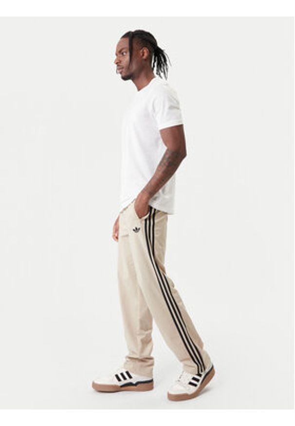 Adidas - adidas Spodnie dresowe Firebird KE6679 Beżowy Loose Fit. Kolor: beżowy. Materiał: syntetyk
