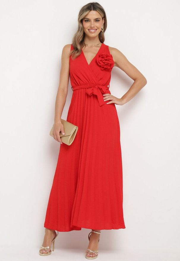 Born2be - Czerwona Plisowana Sukienka z Paskiem i Gumką w Talii Ozdobiona Broszką Kwiatem Vikmirra. Okazja: na randkę, na imprezę, na wesele, na ślub cywilny. Typ kołnierza: dekolt w kształcie V. Kolor: czerwony. Wzór: aplikacja, kwiaty. Styl: klasyczny, elegancki