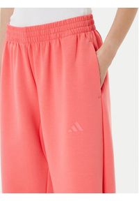 Adidas - adidas Spodnie dresowe ALL SZN Soft Lux lKD9773 Koralowy Loose Fit. Kolor: pomarańczowy. Materiał: syntetyk