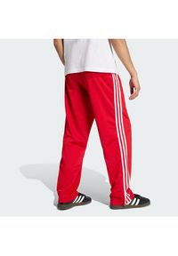 Adidas - adidas Spodnie dresowe Firebird KD8319 Czerwony Loose Fit. Kolor: czerwony. Materiał: syntetyk #4