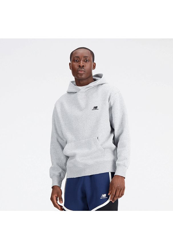 Bluza męska New Balance MT33586AG – szara. Typ kołnierza: kaptur. Kolor: szary. Materiał: bawełna, poliester, prążkowany. Wzór: napisy. Sport: koszykówka