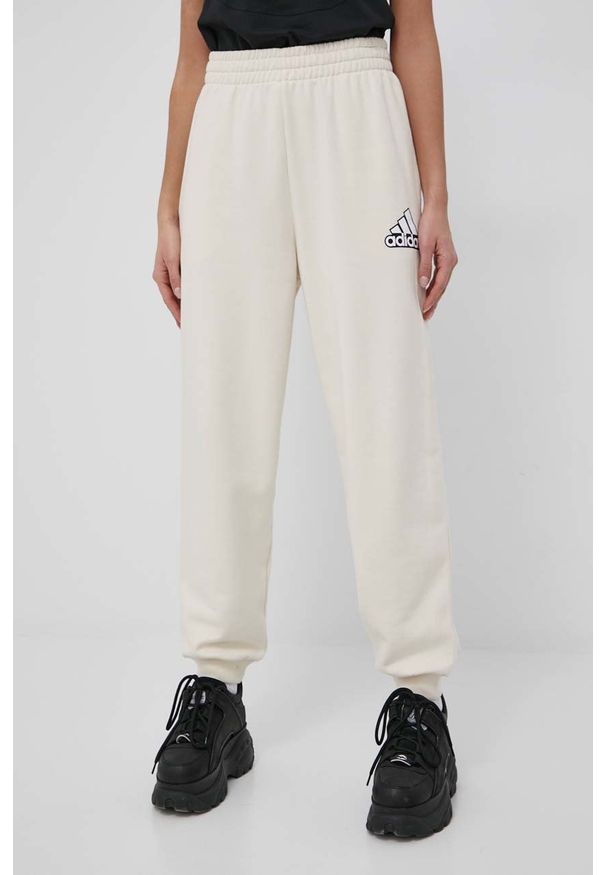 Adidas - adidas spodnie bawełniane HC9175 damskie kolor beżowy z nadrukiem. Kolor: beżowy. Materiał: bawełna. Wzór: nadruk