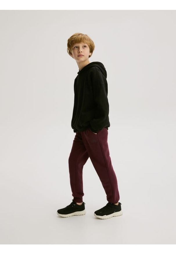 Reserved - Bawełniane joggery z meszkiem - bordowy. Kolor: czerwony. Materiał: bawełna