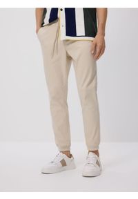 Reserved - Spodnie jogger slim - kremowy. Kolor: kremowy. Materiał: bawełna
