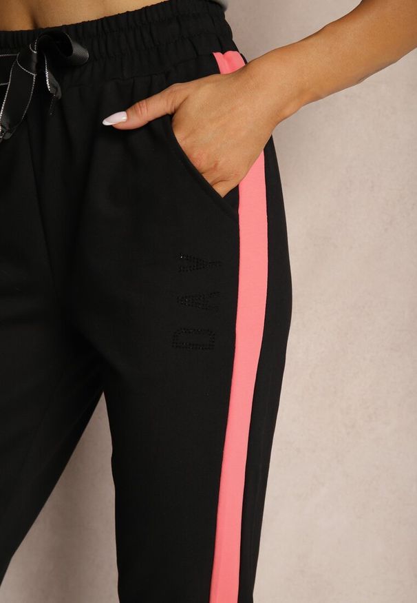 Renee - Czarne Spodnie Dresowe High Waist Wykończone Lampasami i Ozdobione Napisem Sikara. Okazja: na co dzień. Stan: podwyższony. Kolor: czarny. Materiał: dresówka. Długość: krótkie. Wzór: aplikacja, napisy. Styl: sportowy, casual, elegancki