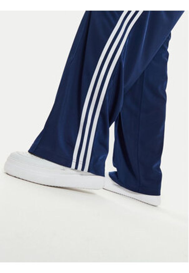 Adidas - adidas Spodnie dresowe Firebird IL3817 Granatowy Loose Fit. Kolor: niebieski. Materiał: syntetyk