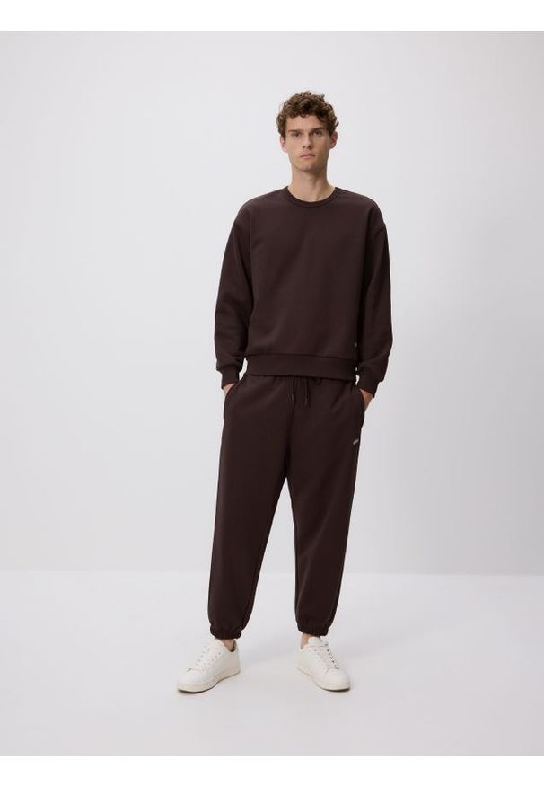 Reserved - Spodnie dresowe comfort fit - brązowy. Kolor: brązowy. Materiał: dresówka