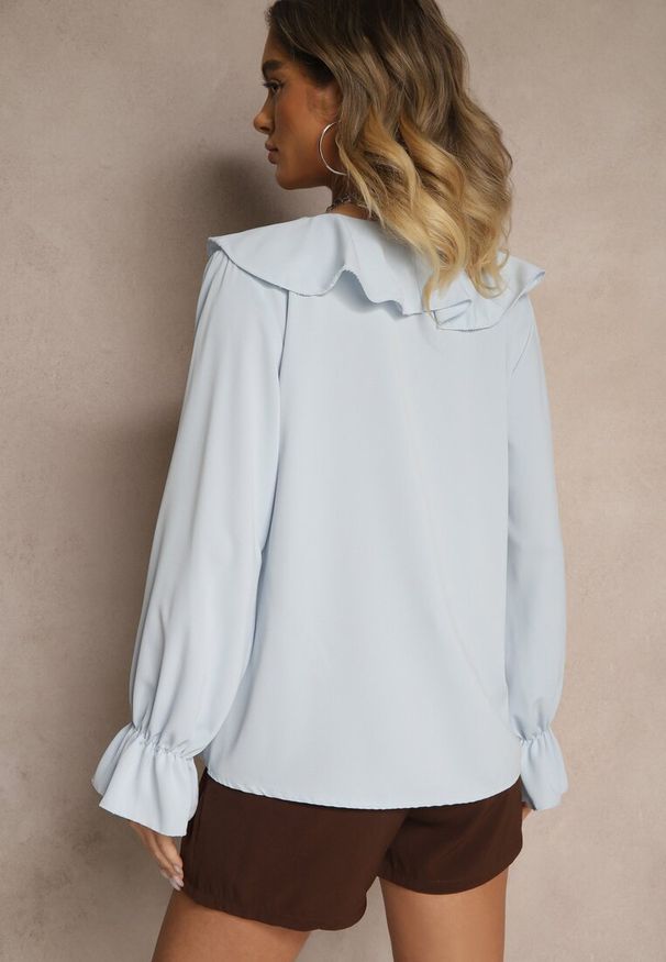 Renee - Jasnoniebieska Bluzka Ozdobiona Falbanką Tananissa. Kolor: niebieski. Wzór: aplikacja. Styl: klasyczny, elegancki