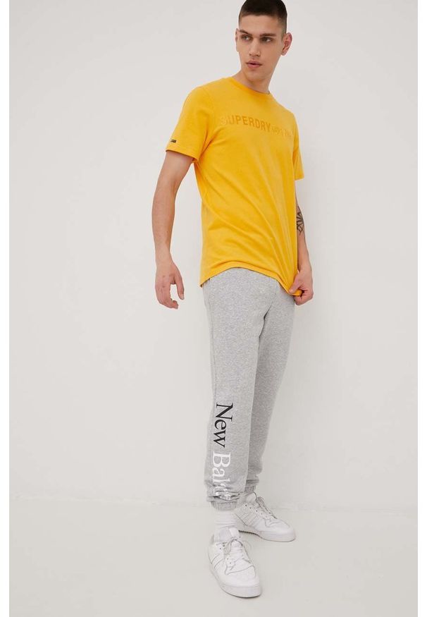 New Balance spodnie dresowe męskie kolor szary melanżowe. Kolor: szary. Materiał: dresówka. Wzór: melanż