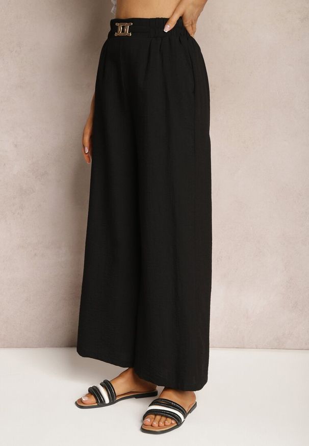 Renee - Czarne Spodnie z Szerokimi Nogawkami w Stylu Palazzo High Waist z Gumką w Pasie z Ozdobnym Elementem Ellsiana. Okazja: na co dzień. Stan: podwyższony. Kolor: czarny. Materiał: bawełna. Styl: elegancki, casual
