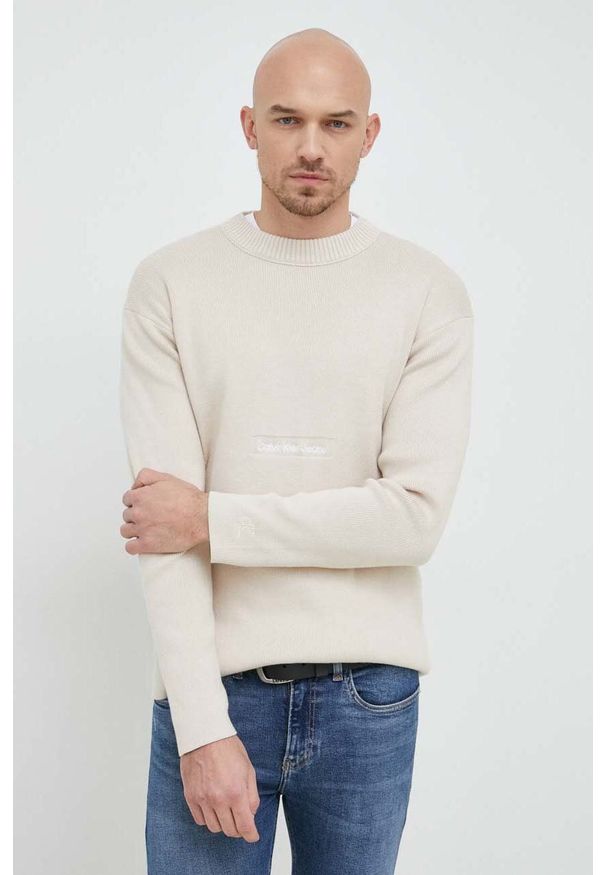 Calvin Klein Jeans sweter bawełniany kolor beżowy. Okazja: na co dzień. Kolor: beżowy. Materiał: bawełna. Wzór: gładki, aplikacja. Styl: casual