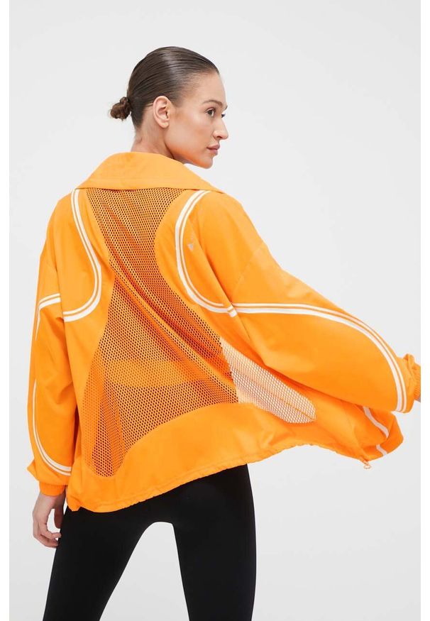 Adidas by Stella McCartney - adidas by Stella McCartney wiatrówka TruePace kolor pomarańczowy przejściowa oversize. Kolor: pomarańczowy. Materiał: materiał