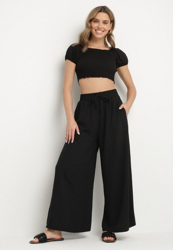 Born2be - Czarne Szerokie Spodnie Typu Palazzo z Wiązaniem Ulialitia. Okazja: na co dzień. Stan: podwyższony. Kolor: czarny. Styl: elegancki, casual