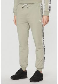 Guess - GUESS Zielone męskie spodnie dresowe z lampasami New Arlo, Rozmiar XL. Kolor: zielony. Materiał: dresówka #1
