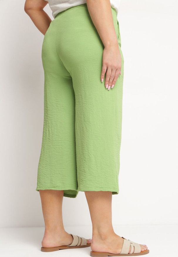 Born2be - Jasnozielone Szerokie Spodnie z Wysokim Stanem z Gumką w Talii i Nogawkami Długości 3/4 Levolia. Okazja: na co dzień. Stan: podwyższony. Kolekcja: plus size. Kolor: zielony. Materiał: jedwab. Styl: casual, elegancki