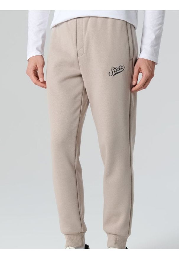 Sinsay - Spodnie dresowe jogger - beżowy. Kolor: beżowy. Materiał: dresówka