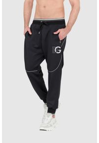 Dolce and Gabbana - DOLCE & GABBANA Czarne spodnie dresowe z dużym logo. Kolor: czarny. Materiał: poliester #7