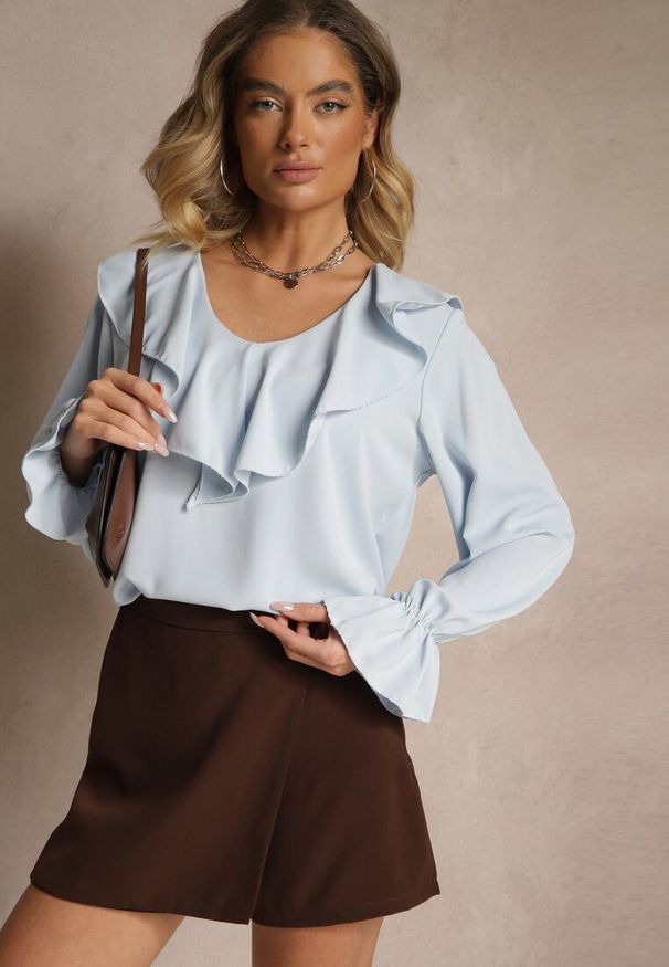 Renee - Jasnoniebieska Bluzka Ozdobiona Falbanką Tananissa. Kolor: niebieski. Wzór: aplikacja. Styl: klasyczny, elegancki