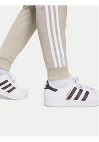Adidas - adidas Spodnie dresowe Sst Track IA2239 Beżowy jasny Regular Fit. Kolor: beżowy. Materiał: syntetyk #7