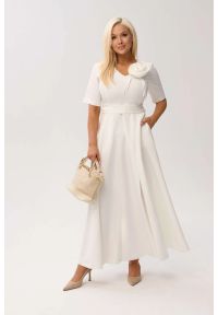 Moda Size Plus Iwanek - Sukienka MAXI Mirabella w odcieniu ecru/śmietankowej bieli z odpinanym kwiatem i kokardą OVERSIZE PLUS SIZE XXL WIOSNA LATO. Okazja: na urodziny, na wesele, na komunię, na ślub cywilny, na imprezę. Typ kołnierza: kokarda. Kolekcja: plus size. Wzór: kwiaty. Typ sukienki: oversize, dla puszystych. Materiał: tkanina, materiał, poliester, elastan. Sezon: lato, wiosna. Styl: elegancki, klasyczny. Długość: maxi #1