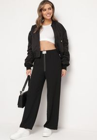Born2be - Czarne Spodnie Szerokie z Gumką w Pasie z Ozdobnym Łańcuszkiem Istaria. Okazja: na co dzień. Kolor: czarny. Styl: casual