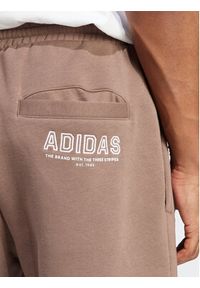 Adidas - adidas Spodnie dresowe IR8362 Brązowy Regular Fit. Kolor: brązowy. Materiał: dresówka, bawełna