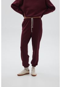 Marsala - Spodnie typu jogger w kolorze BURGUNDY - COOL-XS. Stan: podwyższony. Materiał: guma, dzianina, poliester, dresówka, bawełna. Styl: elegancki
