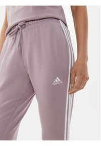 Adidas - adidas Spodnie dresowe Essentials 3-Stripes IR5379 Różowy Slim Fit. Kolor: różowy. Materiał: bawełna