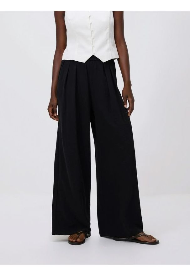 Reserved - Szerokie spodnie - czarny. Kolor: czarny. Materiał: tkanina. Wzór: gładki