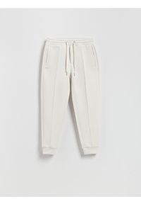Reserved - Spodnie dresowe slim fit - złamana biel. Materiał: dresówka