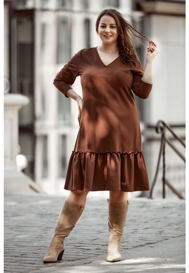 Moda Size Plus Iwanek - Brązowa sukienka Alicja z falbanką XXL OVERSIZE WIOSNA. Kolor: brązowy. Materiał: tkanina, skóra, dzianina, poliester, materiał, dresówka, bawełna. Długość rękawa: długi rękaw. Wzór: aplikacja. Sezon: wiosna. Typ sukienki: oversize